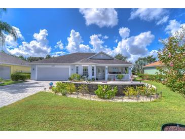 Single-story home with attractive landscaping and a paved driveway at 2440 E Del Webb Blvd, Sun City Center, FL 33573