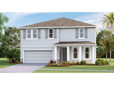 Two-story house with gray siding, a two-car garage, and landscaping at 2577 Chapel Oak Bnd, Wesley Chapel, FL 33543