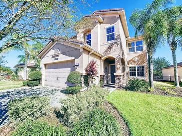 Two-story house with a large front yard, attached garage, and lush landscaping at 2670 Tarragona Way, Wesley Chapel, FL 33543