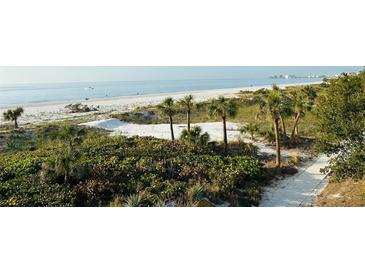 Stunning beach view with white sand and palm trees at 3200 Gulf Blvd # 204, St Pete Beach, FL 33706