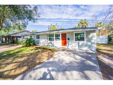 Newly renovated single story home with a red door and well-manicured lawn at 3709 W Oklahoma Ave, Tampa, FL 33611