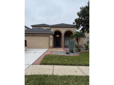 Two-story house with a two-car garage and landscaped front yard at 3830 Stornoway Dr, Land O Lakes, FL 34638