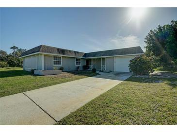 Single-story house with a driveway, lawn, and attached garage at 4173 Driver Ln, Port Charlotte, FL 33981