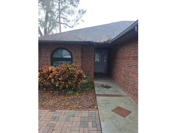 Brick house with gray roof and landscaping at 6549 Brentwood Dr, Zephyrhills, FL 33542