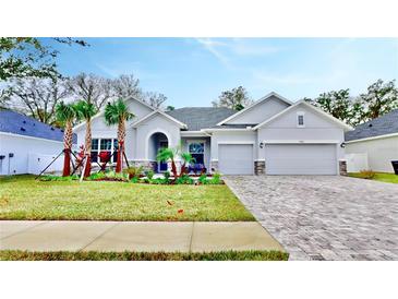 Two-story home with gray exterior, landscaping, and a paved driveway at 7532 Ashbrooke Pine Loop, Odessa, FL 33556