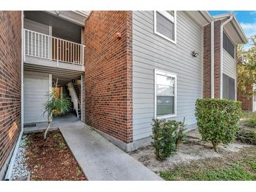 Exterior view showing building with brick and siding, walkway, and landscaping at 1400 Gandy N Blvd # 1407, St Petersburg, FL 33702