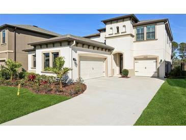 Two-story house with a three-car garage and landscaped front yard at 14838 Paddock Pond Ave, Lithia, FL 33547