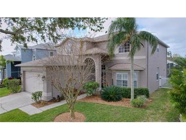 Charming two-story home featuring a well-maintained lawn, mature landscaping, and a welcoming arched entryway at 1632 Gray Bark Dr, Oldsmar, FL 34677