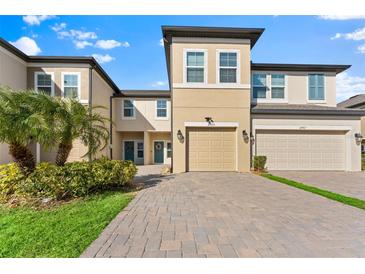 Two-story townhome with a paved driveway and landscaping at 29913 Southwell Ln, Wesley Chapel, FL 33543