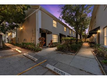 Evening view of townhouse building with walkway and landscaping at 408 S Arrawana Ave # C4, Tampa, FL 33609