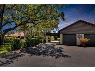 Two-car garage with covered carport and lush landscaping at 4333 Trails Dr # 10-1, Sarasota, FL 34232