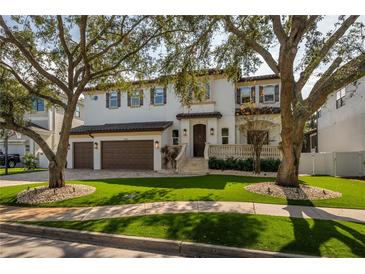 Two-story house with a three-car garage and manicured lawn at 5020 W Dickens Ave, Tampa, FL 33629