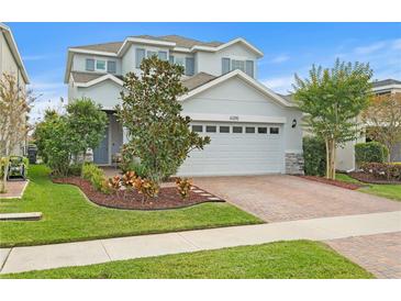 Two-story house with gray siding, brick driveway, and landscaping at 6205 Voyagers Pl, Apollo Beach, FL 33572