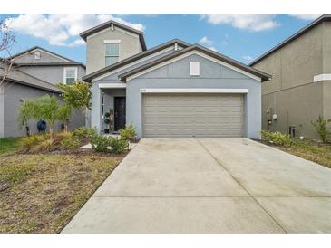 Two-story house with gray exterior, two-car garage, and landscaping at 656 Argyll Dr, Spring Hill, FL 34609