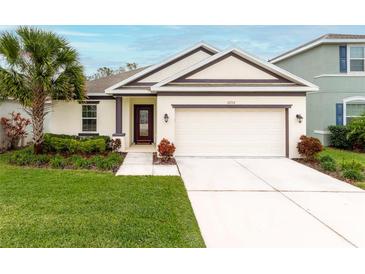 Attractive one-story home with a two-car garage and manicured lawn at 16732 Mooner Plank Cir, Wimauma, FL 33598