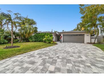 Updated home exterior boasts a modern gray garage door and landscaped front yard at 1927 Montana Ne Ave, St Petersburg, FL 33703