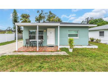 Quaint teal home with covered porch and well-manicured lawn at 206 N Himes Ave, Tampa, FL 33609