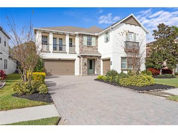 Two-story home with stone accents and a three-car garage at 28475 Marsciano Ln, Wesley Chapel, FL 33543