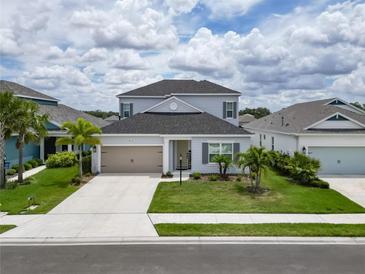 Two-story home with gray siding, neutral accents, and a two-car garage at 3322 Woodmont Dr, Parrish, FL 34219