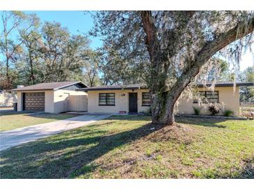 Charming single-story home featuring a spacious front yard and a detached two-car garage at 38214 Jendral Ave, Zephyrhills, FL 33542