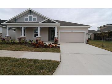 Single-story home with a covered porch and attached garage at 5917 Hidden Branch Dr, Apollo Beach, FL 33572