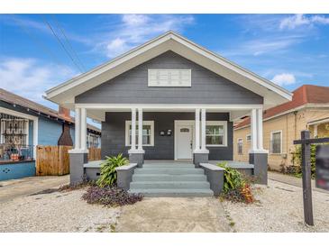 Gray house with white trim, front porch, and landscaped yard at 915 E 20Th Ave, Tampa, FL 33605