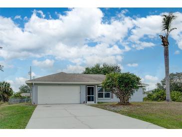Single-story home with attached garage and landscaped yard at 2369 N Biscayne Dr, North Port, FL 34291