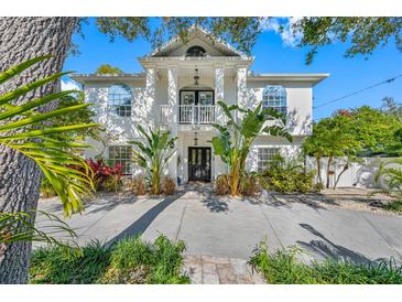 Two-story house with white exterior, landscaping, and a circular driveway at 3031 W Asbury Pl, Tampa, FL 33611