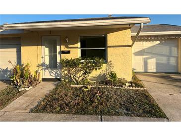Exterior view of a charming yellow house with a well-maintained lawn and driveway at 4939 Docner St, New Port Richey, FL 34652