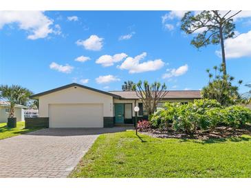 Beautiful mid-century modern home with a landscaped lawn and paver driveway at 5215 Dover Ne St, St Petersburg, FL 33703