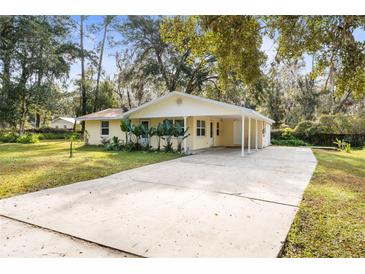 Yellow house with carport and large yard at 708 Buena Vista Ave, Brooksville, FL 34601