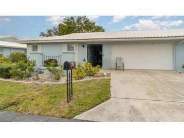 Light blue house with a white roof, landscaped yard, and a two-car garage at 804 67Th W St, Bradenton, FL 34209