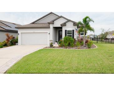 One-story home with gray siding, landscaping, and a two-car garage at 8203 Abalone Loop, Parrish, FL 34219