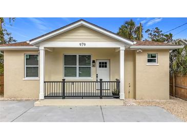 Charming front exterior of home with covered porch and neutral stucco at 962 James S Ave, St Petersburg, FL 33705