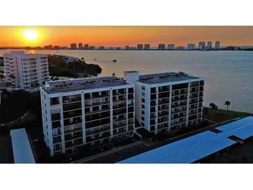 Aerial view of waterfront condo building at sunset at 100 Oakmont Ln # 309, Belleair, FL 33756