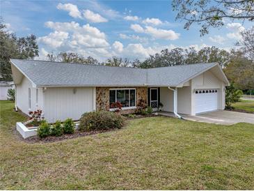 Ranch-style home with stone accents and a well-maintained lawn at 1559 Glengarry Dr, Palm Harbor, FL 34684