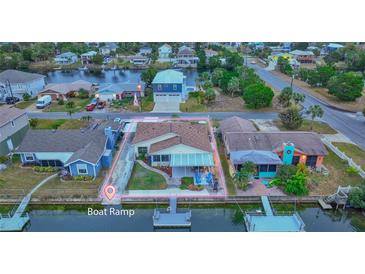 Aerial view of single-story home with canal access, boat ramp nearby at 3339 Poinsettia Dr, Hernando Beach, FL 34607