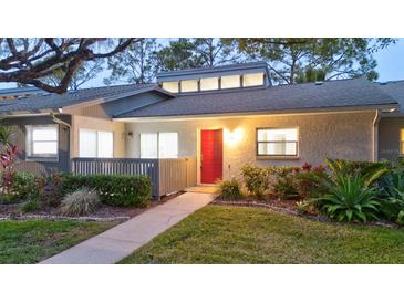 Inviting exterior with red door and landscaped walkway at 40 Aster Pl, Oldsmar, FL 34677