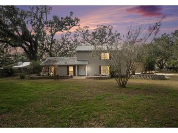 Two-story house with a landscaped yard at dusk at 8575 Carey Rd, Lithia, FL 33547