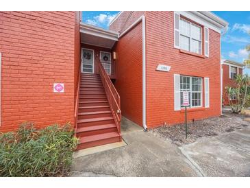 Red brick building exterior with stairs and landscaping at 1290 83Rd N Ave # D, St Petersburg, FL 33702