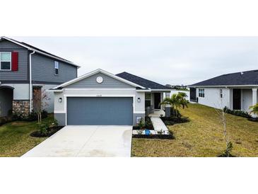 Single-story home with gray siding, two-car garage, and landscaped lawn at 2667 89Th Street E Cir, Palmetto, FL 34221