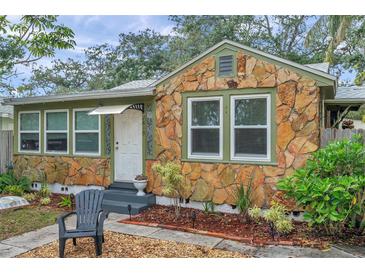 Charming stone cottage with a green exterior and landscaped front yard at 2819 50Th S St, Gulfport, FL 33707