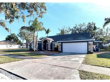House exterior boasts a stone and blue facade, a large garage, and a well-manicured lawn at 4101 Concord Way, Plant City, FL 33566