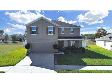 Two-story house with gray siding, brown accents, and a two-car garage at 4179 Bramblewood Loop, Spring Hill, FL 34609