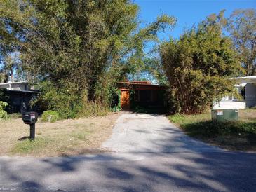 House exterior with green and orange siding, a paved driveway, and mature bamboo at 5209 10Th S Ave, Gulfport, FL 33707