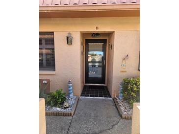 Inviting condo entry with a black door and landscaped walkway at 19029 Us Highway 19 N # 32B, Clearwater, FL 33764