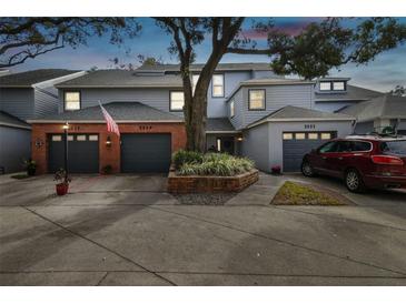 Two-story townhome with gray siding, brick accents, and attached garages at 2519 Crowder Ln, Tampa, FL 33629