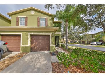 Green two-story townhome with brown garage doors and landscaping at 2803 Santego Bay Ct, Brandon, FL 33511