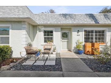 Inviting condo entry with sitting area, stone pathway, and well-manicured landscaping at 3717 Trophy Blvd, New Port Richey, FL 34655