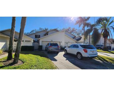 Well-maintained townhome with an attached garage, driveway, and a lush green lawn at 440 Lakeview Dr # 33, Palm Harbor, FL 34683